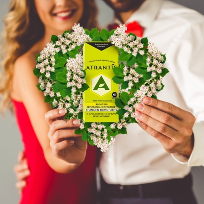 Couple holding Valentine's day heart with a box of Atrantil in it