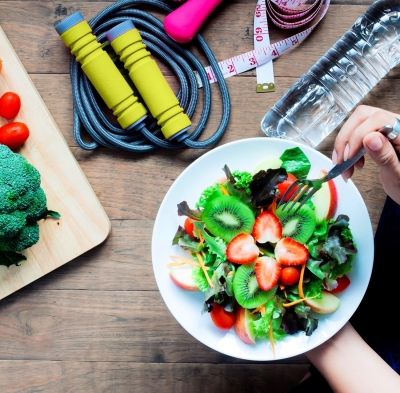 Someone holding a salad and jump-rope on the table showing the Benefits of Good Nutrition