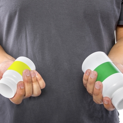 Guy holding two pill bottles